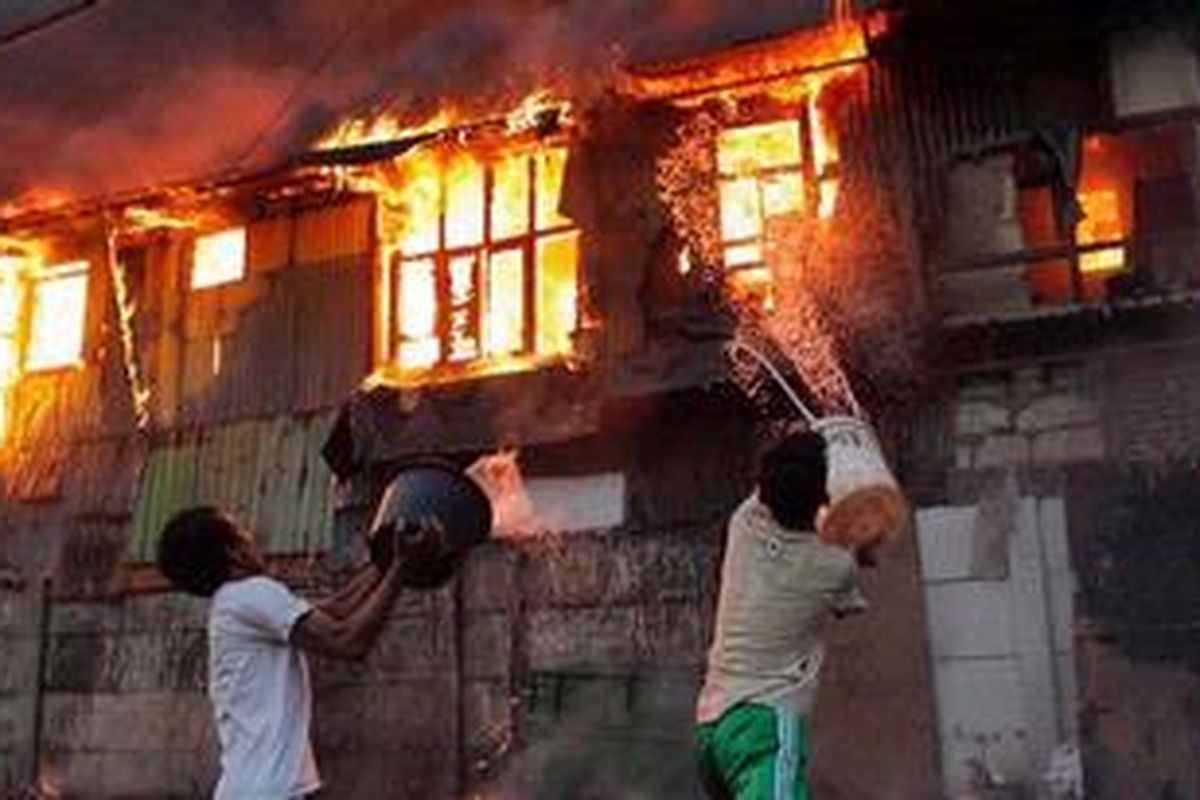 Warga berusaha memadamkan api dengan alat seadanya pada kebakaran yang melalap pemukiman di Kampung Duri Selatan, Tambora, Jakarta Barat, Kamis (7/2/2013). Akibat besarnya api puluhan rumah yang berada di tepi rel kereta itu habis terbakar.