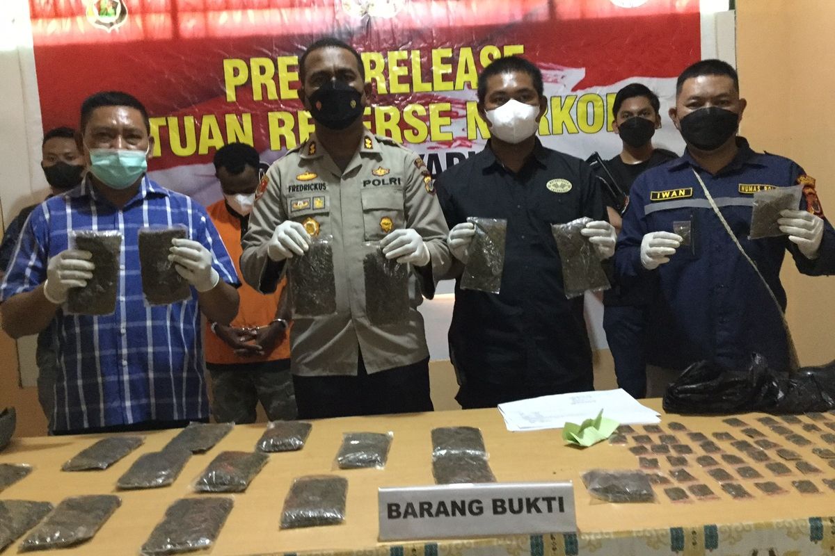Kapolres Jayapura, AKBP Fredrickus W.A Maclarimboen (tengah) disampingi pejabat dari Satuan Narkoba Polres Jayapura dan Humas Polres Jayapura, saat menunjukkan ganja yang diamankan oleh pelaku di Bandara Sentani Jayapura, Papua disela-sela konferensi pers yang berlangsung di Polres Jayapura, Rabu (25/05/2022).