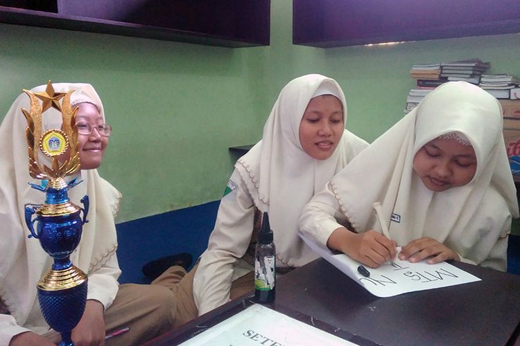 Yulistya Rahma Fitri, Nurmala Sholikah Rusdi, dan Indriyani, menunjukkan tinta dari daun jambu biji hasil kreasi mereka.