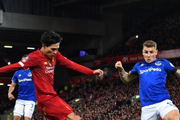 Pemain tengah Liverpool asal Jepang, Takumi Minamino (kiri) bersaing dengan bek Everton asal Prancis Lucas Digne (kanan) selama pertandingan sepak bola putaran ketiga Piala FA Inggris antara Liverpool dan Everton di Anfield di Liverpool.