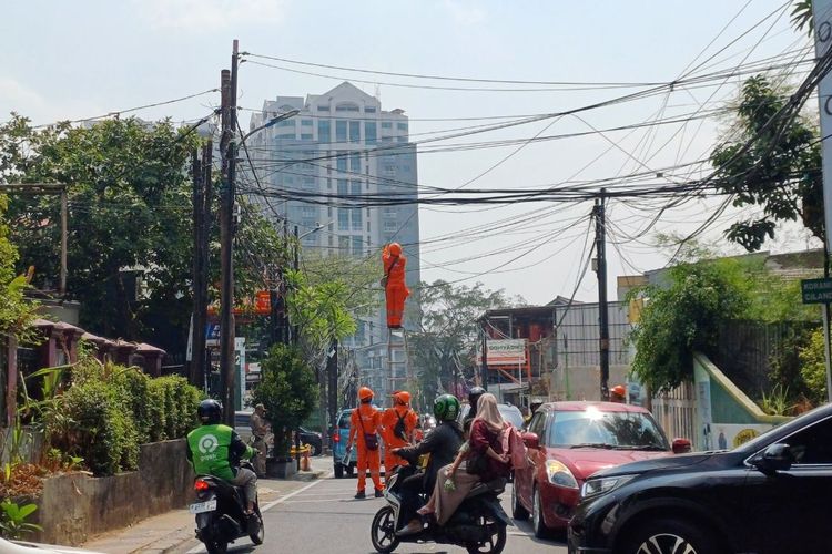 Petugas PPSU Kelurahan Cilandak Barat tengah merapikan kabel utilitas yang menjuntai di Jalan Terogong Raya, Selasa (3/10/2023).