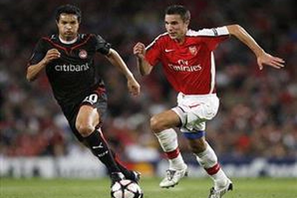 Penyerang Arsenal, Robin van Persie (kanan) mencoba menembus pertahanan Olympiakos dalam kawalan gelandang Dudu, dalam lanjutan babak penyisihan Liga Champions, Selasa (29/9).