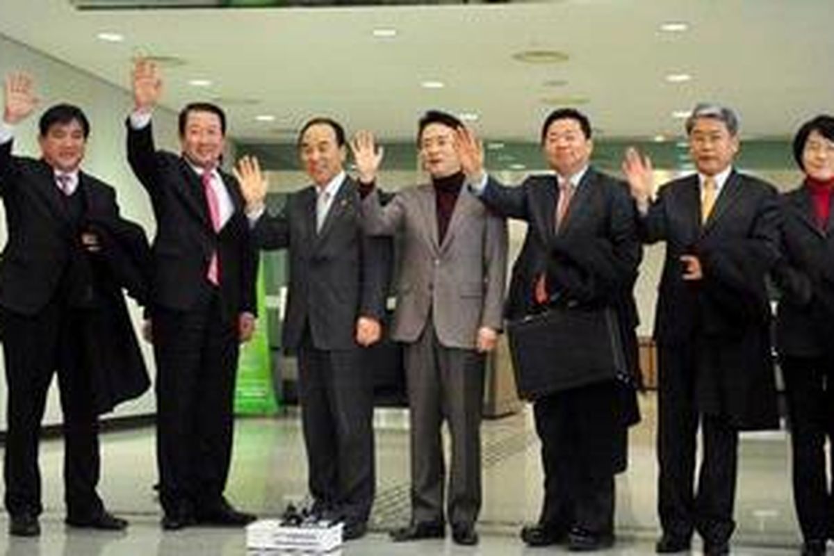 Sejumlah anggota DPR Korea Selatan, baik dari partai pemerintah maupun kelompok oposisi, melambaikan tangan sebelum bertolak ke kawasan industri di Kaesong di Korea Utara, Jumat (10/2/2012). Kawasan industri itu dikelola bersama oleh kedua negara yang berseteru tersebut.  