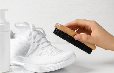 Ilustrasi membersihkan sepatu putih.