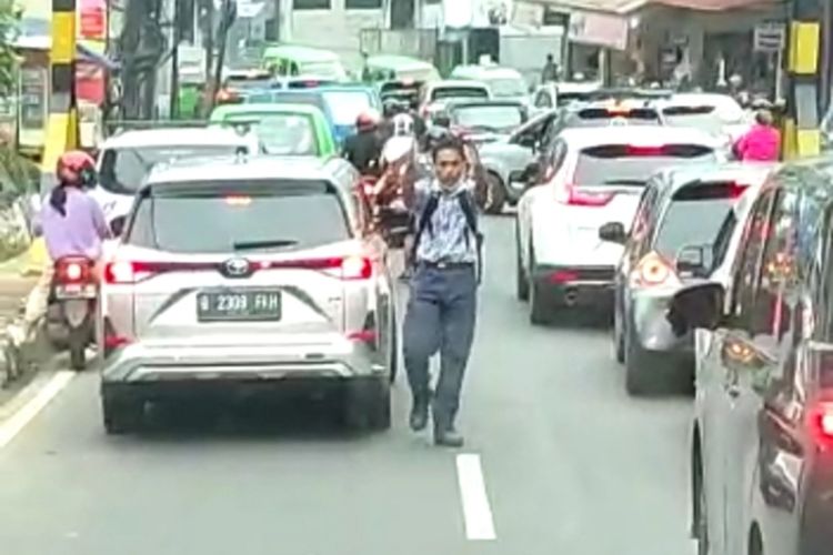 Seorang siswa SMP membantu mobil Damkar keluar dari kemacetan di Jalan Raya Empang, kawasan Bogor Trade Mall (BTM), Kota Bogor, Jawa Barat, pada Kamis (19/1/2023).