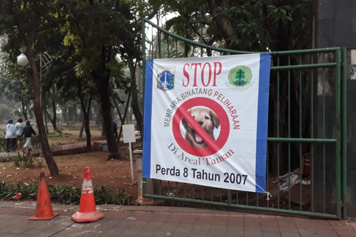 Spanduk larangan membawa hewan peliharaan ke Kebun Bibit Tebet, Jakarta Selatan, dipasang di pagar masuk kebun tersebut. Foto diambil Jumat (27/7/2018).