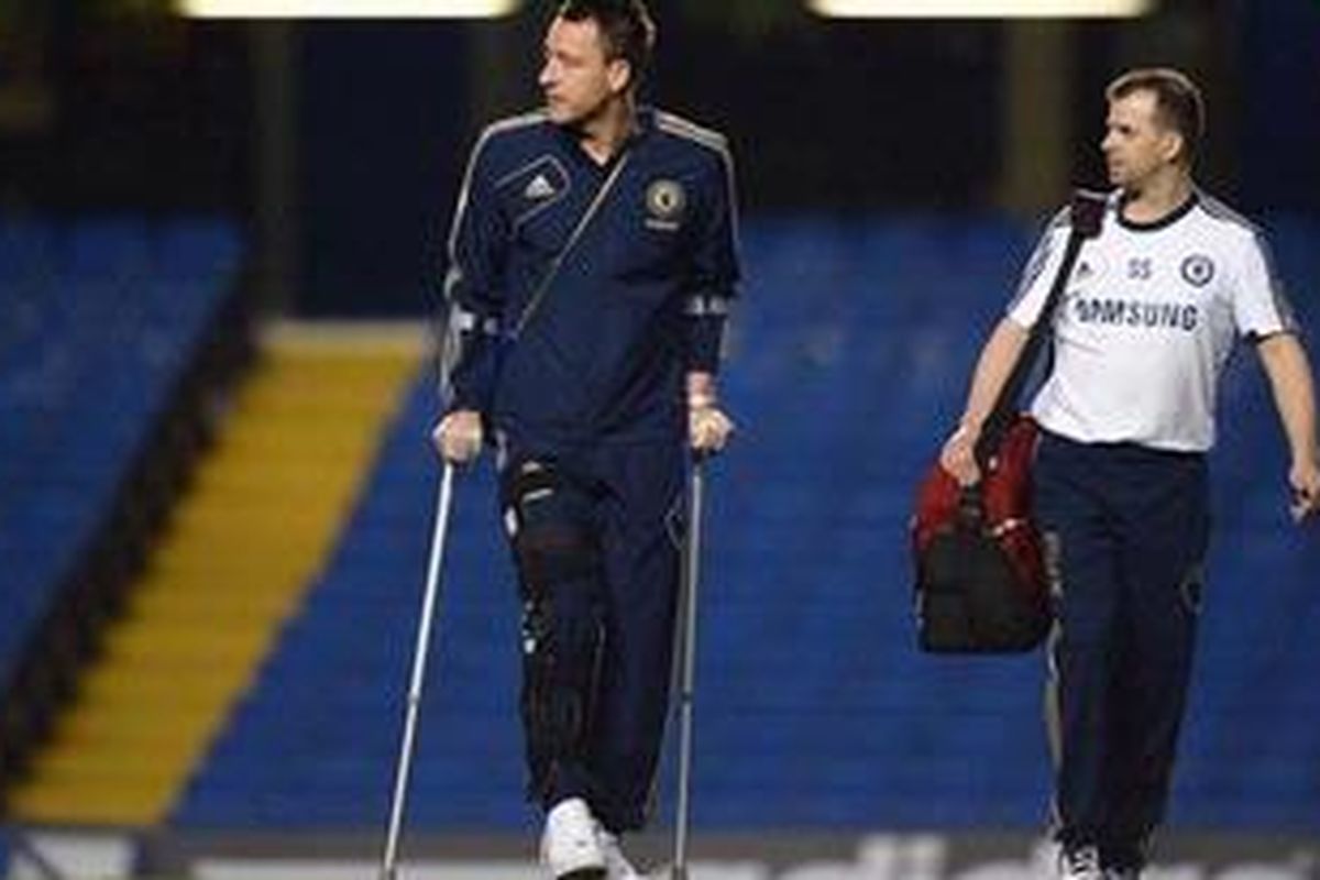 Bek Chelsea, John Terry (kiri), berjalan dengan alat bantu setelah pertandingan melawan Liverpool di Stadion Stamford Bridge, Minggu (11/11/2012). Laga pekan ke-11 Premier League itu berakhir 1-1. 