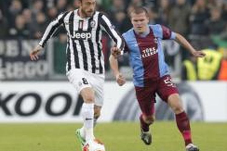 Gelandang Juventus, Claudio Marchisio (kiri), mendapat pengawalan dari pemain Trabzonspor, Alexandru Bourceanu (kanan), pada laga babak 32 besar Liga Europa di Stadion Juventus, Turin, Kamis (20/2/2014).