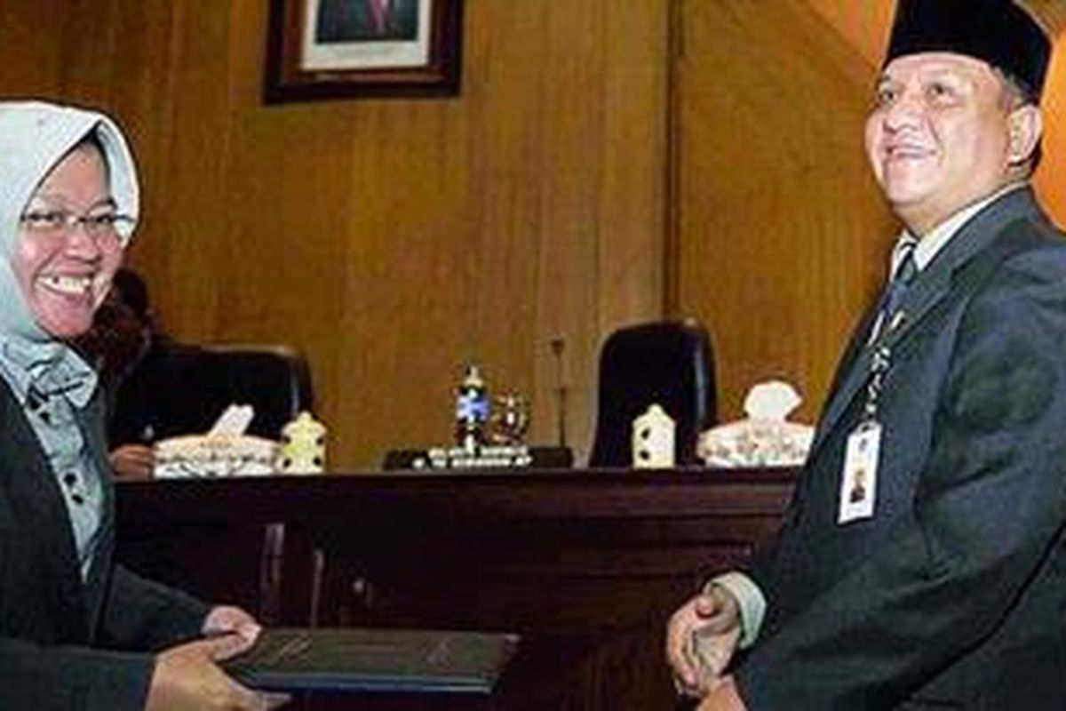 Ketua DPRD Kota Surabaya Whisnu Wardhana (kanan), Rabu (8/12/2010) di Gedung DPRD, menyerahkan naskah pendapat akhir DPRD kepada Wali Kota Surabaya Tri Rismaharini terkait dengan interpelasi atas kenaikan pajak reklame. DPRD meminta Wali Kota mencabut peraturan wali kota yang mengatur tarif baru pajak reklame.