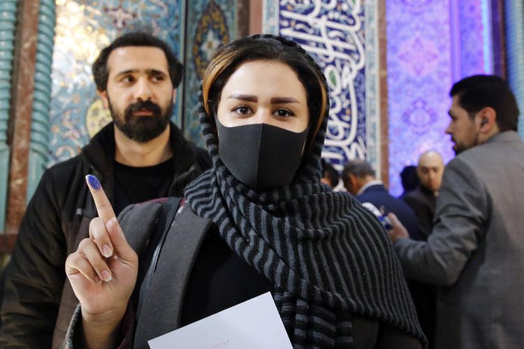 epa08234180 An Iranian woman wearing a face mask shows her inked finger after casting her ballot at a polling station set up at the Abdol Azim shrine during the parliamentary elections in Shahr-e-Ray, Tehran Province, Iran, 21 February 2020. Iranians are heading to the polls to elect their representatives to the Islamic Consultative Assembly amid a worsening economic crisis and escalating tensions with the US.  EPA-EFE/ABEDIN TAHERKENAREH