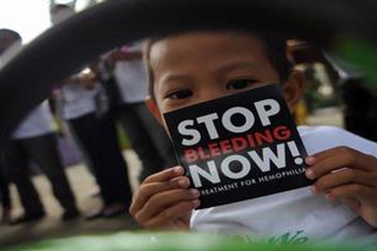 Penderita Hemofilia, Galang Madukara (5), menunjukkan stiker yang akan dibagikannya saat Aksi Damai Peringatan Hari Hemofilia Sedunia di RSUD dr Soetomo, Surabaya, Jawa Timur, Rabu (17/4/2013). Selain bentuk terimakasih kepada tenaga medis, Aksi yang diselenggarakan oleh Himpunan Masyarakat Hemophilia (HMHI) Jawa Timur tersebut merupakan sosialisi mengenai penyakit dan meminta kepada masyarakat untuk menciptakan kondisi yang mendukung  bagi penderita.
