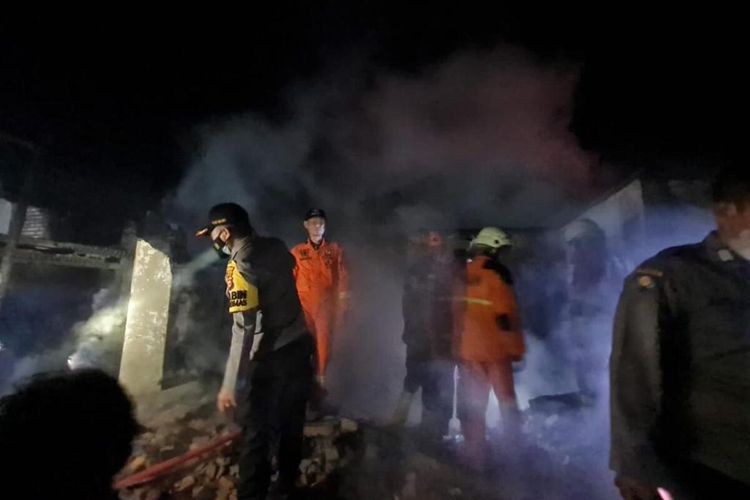 Petugas kepolisian dan tim pemadam kebakaran menyisir rumah yang terbakar yang menewaskan ibu dan tiga anaknya di Desa Kubang Jaya, Kecamatan Siak Hulu, Kabupaten Kampar, Riau, Minggu (7/11/2021) malam.