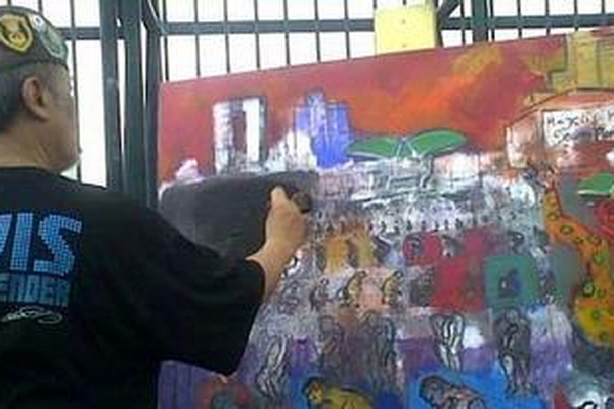 Mpu M Hardi sedang menyempurnakan lukisannya yang bercerita bahwa anggota DPR buang air besar atas kekuasaannya sebagai wakil rakyat.