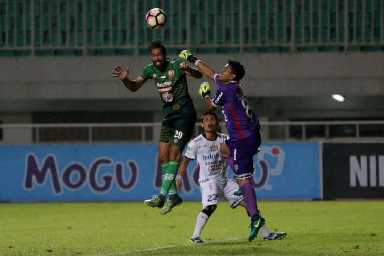 Pemain PS TNI Elio Bruno (kiri) berebut bola dengan penjaga gawang Bali United Wawan Hendrawan (kanan) pada pertandingan lanjutan Liga 1 di Stadion Pakansari, Cibinong, Bogor, Senin (10/7/2017).Bali United menang setelah menundukkan PS TNI dengan skor akhir 4-3. 