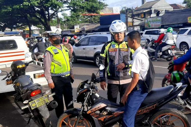 Polisi melakukan penindakan terhadap pelajar yang tidak menggunakan helm di Jalan Transyogi, tepatnya di dekat Pospol Nagrak, Kecamatan Gunung Putri, Kabupaten Bogor, Jawa Barat, Senin (24/10/2022)