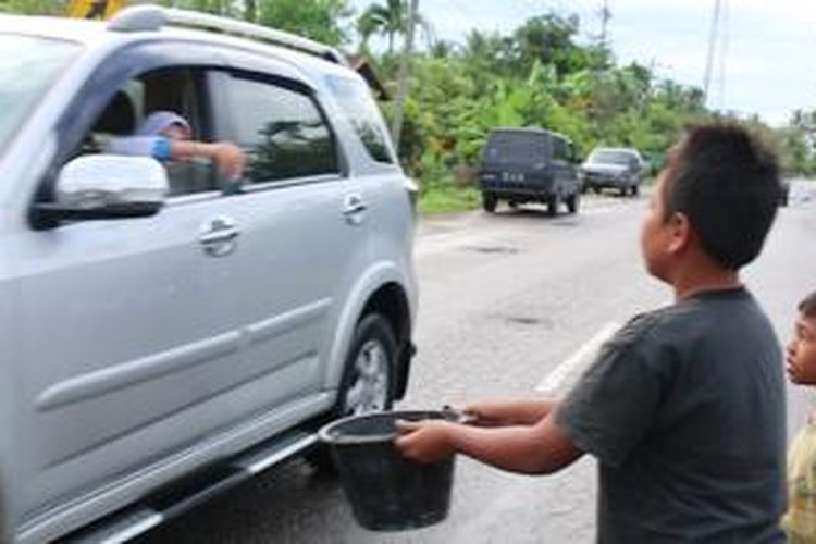 Para korban banjir di Kabupaten Aceh utara meminta bantuan dari para pengguna jalan, Sabtu (27/12/2014)