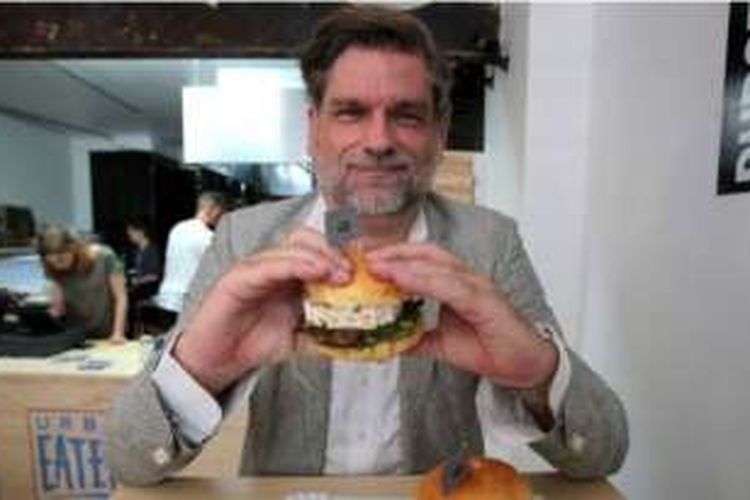 Joerg Tiemann memegang burger Erdogan yang dijual tokonya di kota Koln, Jerman.