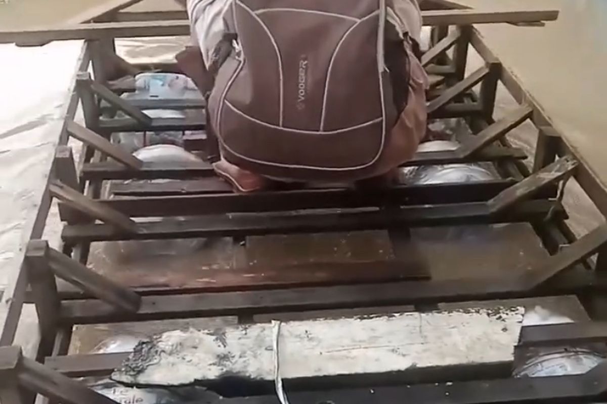 Maksudi Rifai saat antar anaknya berangkat sekolah naik perahu galon rakitan menyusuri pemukiman yang terendam banjir rob di Desa Eretan Wetan, Kecamatan Kandanghaur, Kabupaten Indramayu, Kamis (20/11/2025).