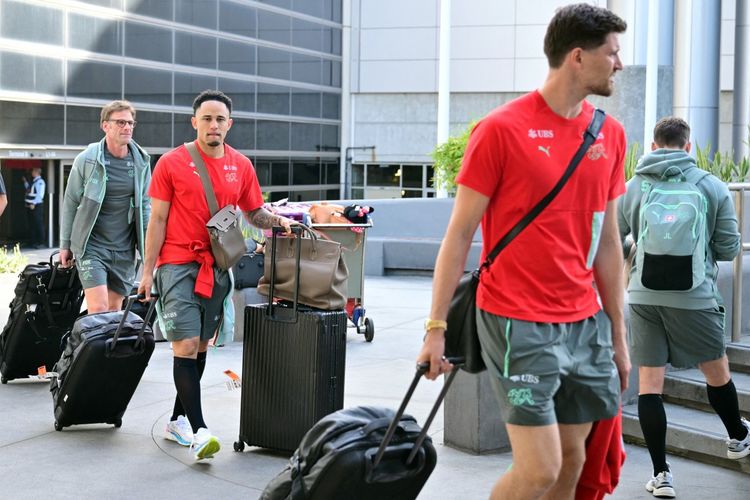 Noah Okafor (tengah) dan kiper Gregor Kobel (kanan) keluar dari terminal saat tim Swiss tiba di Bandara Internasional Los Angeles (LAX) di Los Angeles, California pada 2 Juni 2026 menjelang Piala Dunia 2026. (Foto oleh Frederic J. Coklat / AFP)