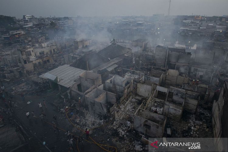 Petugas memadamkan sisa api yang membakar perkampungan padat penduduk di Jalan Lindung Pasar Baru, Teluk Gong, Jakarta Utara, Sabtu (17/7/2021). Kebakaran yang belum bisa dipastikan pemicunya itu menghanguskan ratusan rumah dan menyebabkan sekitar 600 warga kehilangan tempat tinggalnya.