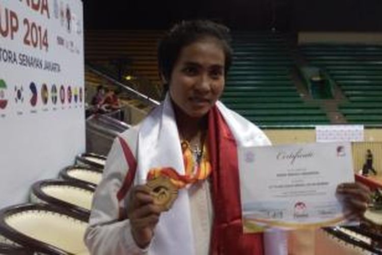 Pesanda Moria Manalu menunjukkan medali emas dan piagam penghargaab sebagai juara dunia Sanda kelas 65 kilogram putri di Istora Senayan, Jakarta, Jumat (21/11/2014).