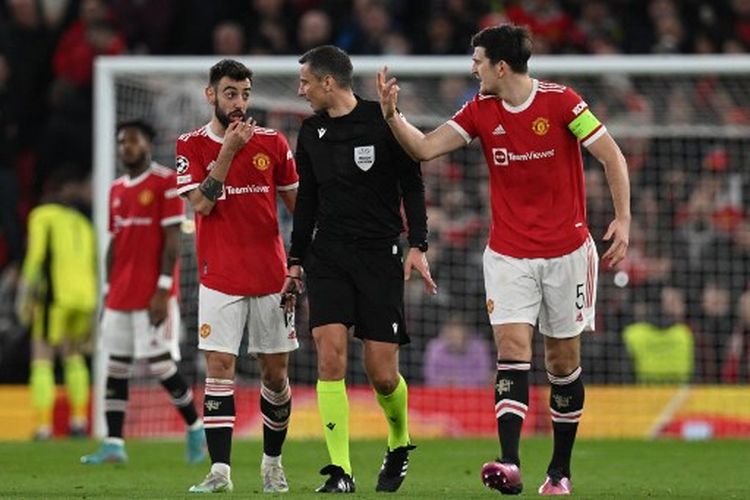 Bruno Fernandes (kiri) dan Harry Maguire (kanan) melontarkan protes ke wasit Slavko Vincic pada laga leg kedua 16 besar Liga Champions yang mempertemukan Man United vs Atletico Madrid di Stadion Old Trafford, Rabu (16/3/2022) dini hari WIB. Hasil Man United vs Atletico Madrid 0-1 untuk kemenangan tim tamu. Man United tersingkir dari Liga Champions setelah kalah agregat 1-2 dari Atletico Madrid.