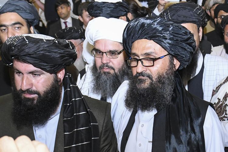 Salah satu pendiri Taliban, Mullah Abdul Ghani Baradar (kanan) meninggalkan ruangan setelah menandatangani perjanjian damai dengan Amerika Serikat (AS) di Doha, Qatar, Sabtu (29/2/2020).