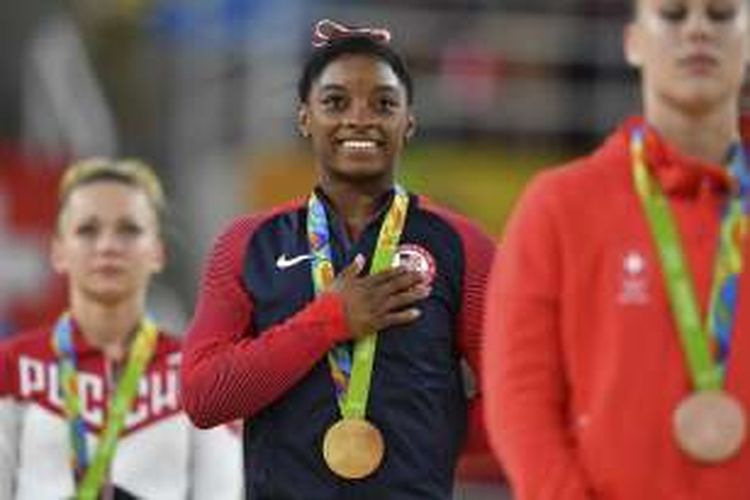 Pesenam putri Amerika Serikat, Simone Biles (tengah), menjalani seremoni di atas podium setelah memenangi noor vault (meja lompat) pada Olimpiade Rio di Olympic Arena, Rio de Janeiro, Brasil, Minggu (14/8/2016).