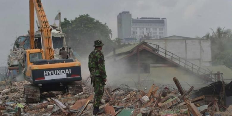 Seorang tentara menyaksikan eksekusi pembongkaran bangunan di Kalijodo, Jakarta, Senin (29/2/2016). Kawasan yang kerap dikenal sebagai tempat hiburan malam itu akan menjadi ruang terbuka hijau.