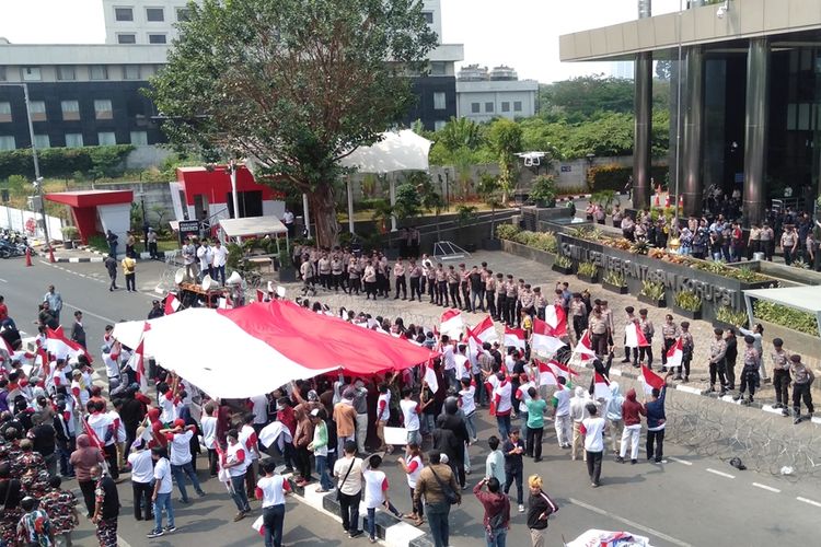Massa aksi dari Srikandi Milineal dan MPD mengibarkan bendera raksasa di depan gedung KPK, Kuningan, Jakarta Selatan, Senin (23/9/2019)