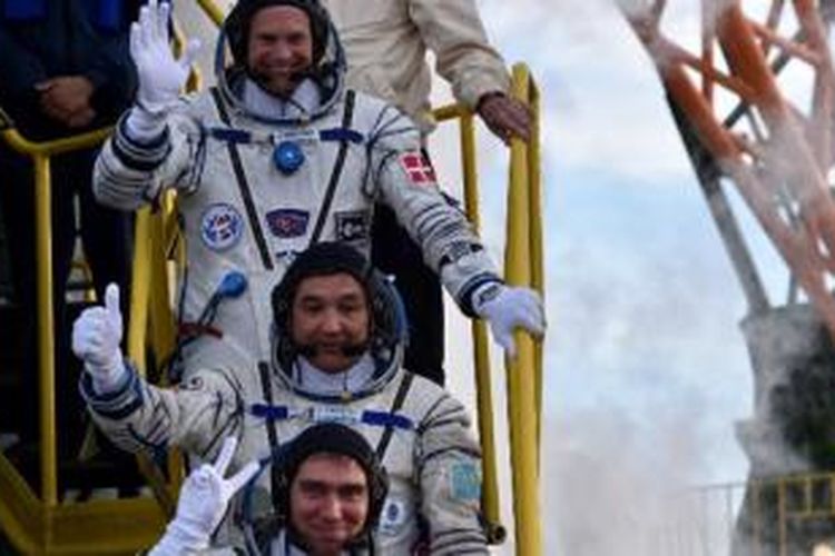 Kosmonot Kazakhstan Aydyn Aimbetov (tengah), kosmonot Rusia Sergei Volkov (bawah), dan astronot Denmark Andreas Mogensen saat turun dari Soyuz TMA-18M di Baikonur, tertanggal 2 September 2015. 