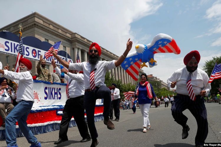 Pria menari di samping kendaraan hias Sikh Amerika selama perayaan Hari Kemerdekaan Empat Juli di Washington, AS, 4 Juli 2019.
