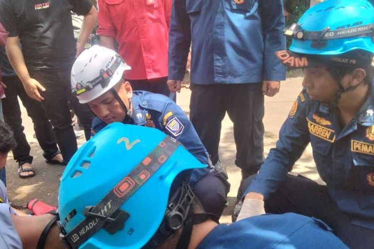 Petugas Diskar PB tengah mengevakuasi jasad kakek yang meninggal di atas pohon, Jumat (14/2/2025)
