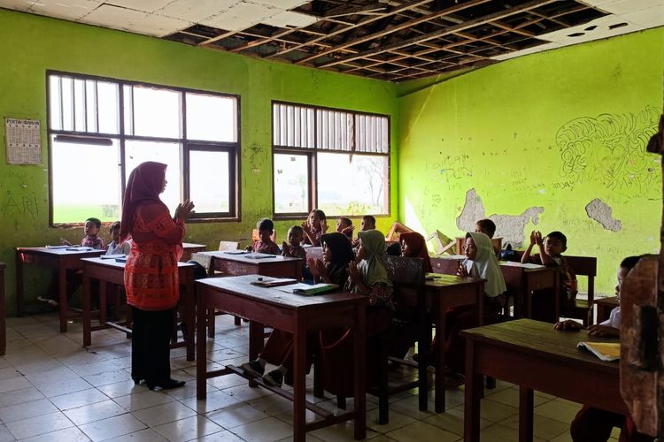Proses belajar mengajar di SD Negeri Sukadaya 02, Kecamatan Sukawangi, Kabupaten Bekasi. Keadaan atap plafon yang berlubang dan bocor membuat segala proses kegiatan di sekolah tersebut bergantung oleh cuaca. 
