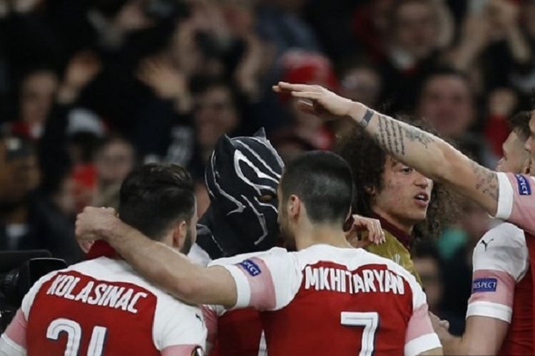 Striker Arsenal, Pierre-Emerick Aubameyang, mengenakan topeng saat merayakan gol dengan rekan-rekan setim pada leg kedua babak 16 besar Liga Europa antara Arsenal vs Rennes di Stadion Emirates pada 14 Maret 2019.