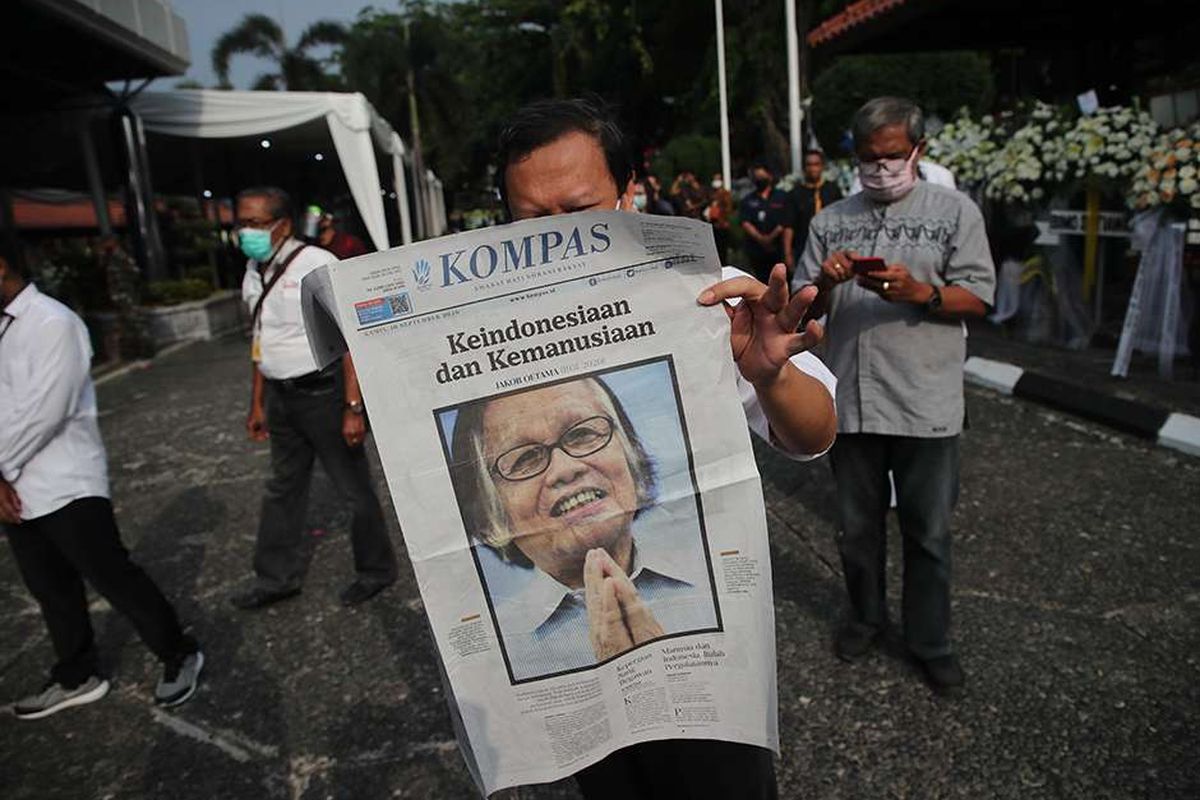 Pelayat membaca Harian Kompas yang menampilkan sosok  Pendiri Kompas Gramedia sekaligus Pemimpin Umum Harian Kompas Jakob Oetama  disela-sela  antre untuk memberikan penghormatan terakhir  di  Gedung Kompas Gramedia, Palmerah Selatan, Jakarta, Rabu (9/9/2020). Jakob Oetama tutup usia pada Kamis (10/9) pada usia ke 88  tahun di Rumah Sakit Mitra Keluarga Kelapa Gading, Jakarta. Selanjutnya, jenazah dikebumikan di  Taman Makam Pahlawan Kalibata, Jakarta, pada  Kamis (10/9).