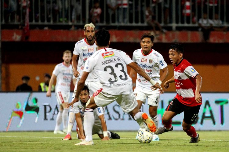 Pemain Madura United Syahrian Abimanyu berebut bola dengan pemain Bali United saat Pekan 15 Liga 2019 yang berakhir dengan skor 0-1 di Stadion Gelora Madura Rate Pamelingan Pamekasan, Jawa Timur, Selasa (20/08/2019) malam.