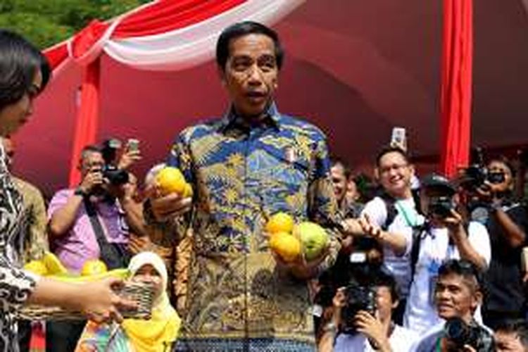 Presiden Joko Widodo saat membagikan buah di acara Fruit Indonesia 2016 di Lapangan Parkir Timur Senayan Jakarta, Kamis (16/11/2016).