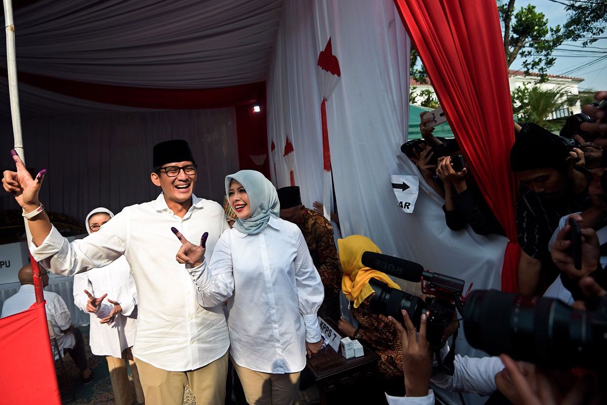 Calon wakil presiden nomor urut 02 Sandiaga Uno (kiri) dan istri Nur Asia Uno (kanan menunjukkan jari yang telah dicelup tinta usai melakukan pencoblosan dalam Pemilu 2019 di TPS 02, Jakarta, Rabu (17/4/2019). Sandiaga tiba di TPS sekitar pukul 07.30 Wib dengan didampingi oleh istri dan kedua anaknya, Anneesha Atheera Uno dan Amyra Atheefa Uno.