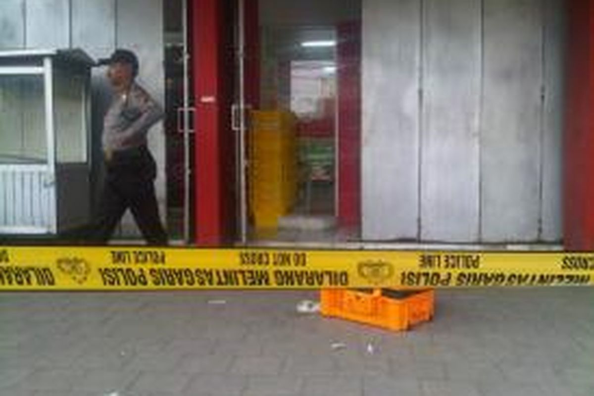 Polisi memasang garis polisi di depan minimarket yang menjadi sasaran pencuri di Jalan KS Tubun, Tegal Selatan, Kota Tegal, Jawa Tengah, Sabtu (07/12/2013).