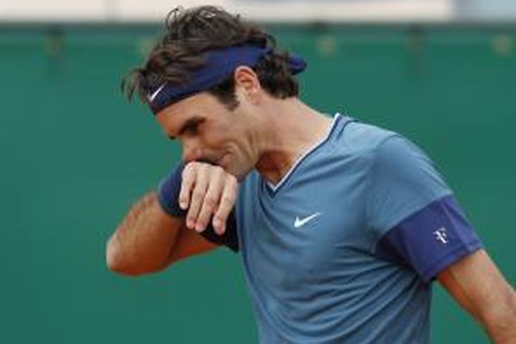 Petenis Swiss Roger Federer mengelap keringat saat menghadapi Radek Stepanek dari Ceko, pada babak kedua Monte Carlo Masters, Rabu (16/3/2014). Federer menang 6-1. 6-2.