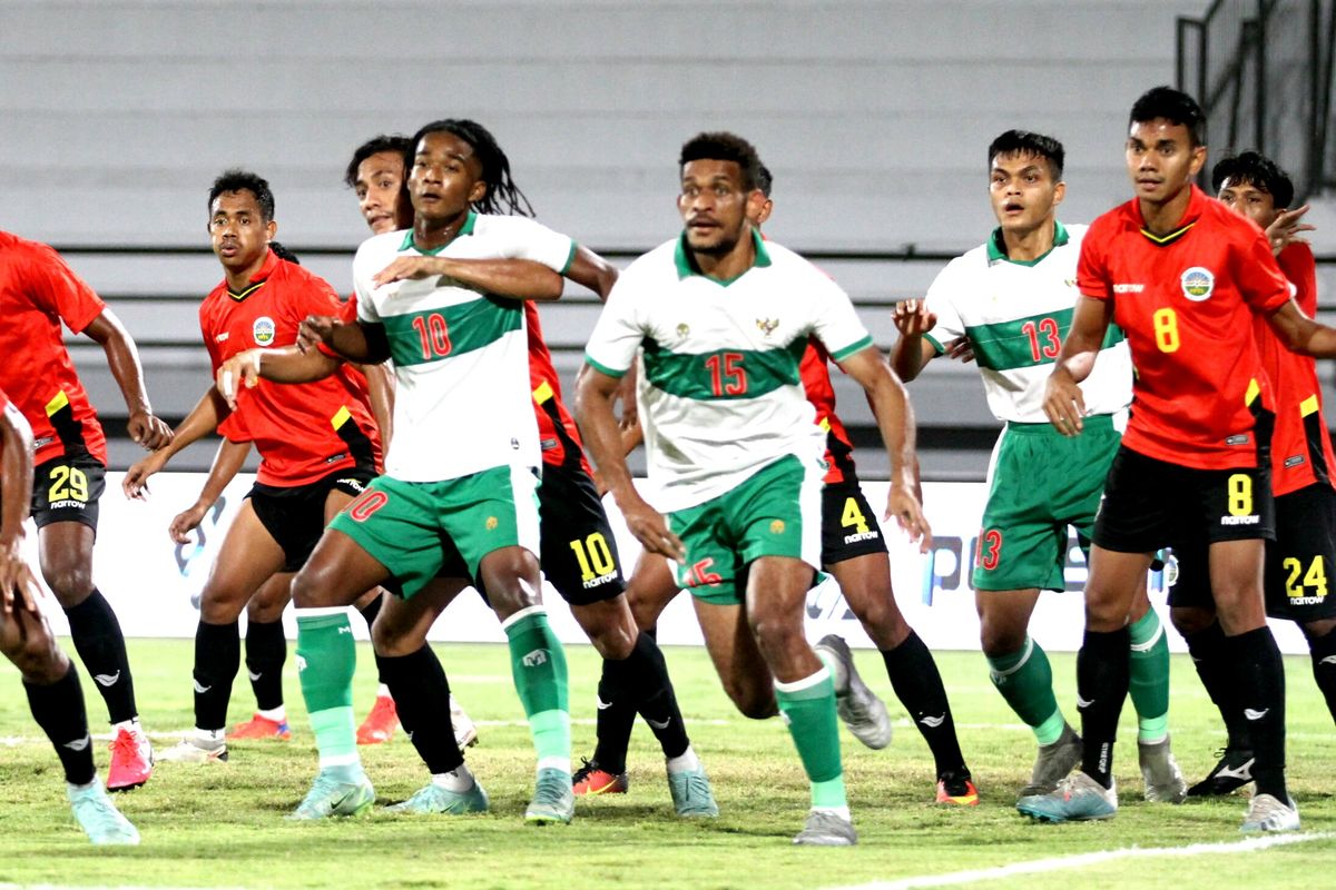 Para pemain timnas Indonesia (putih hijau) mendapat penjagaan dari para pemain Timor Leste dalam laga uji coba FIFA Matchday Indonesia vs Timor Leste, Minggu (30/1/2022).