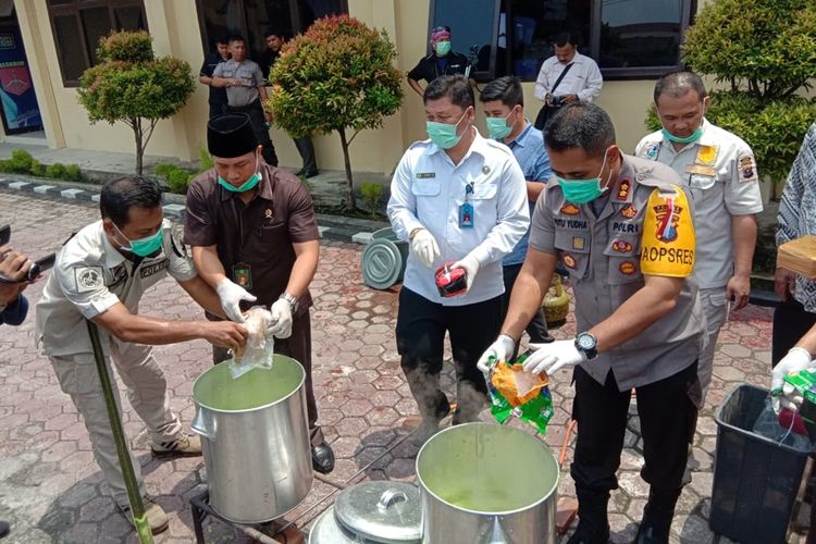 Kapolres Tanjung Balai, AKBP Putu Yudha Prawira memasukkan sabu ke dalam tong berisi air panas dalam pemusnahan barang bukti narkotika jenis sabu dan ekstasi. Sebanyak 18,8 kg sabu dan 9.840 buir ekstasi dimusnahkan pada Rabu siang tadi (16/10/2019).