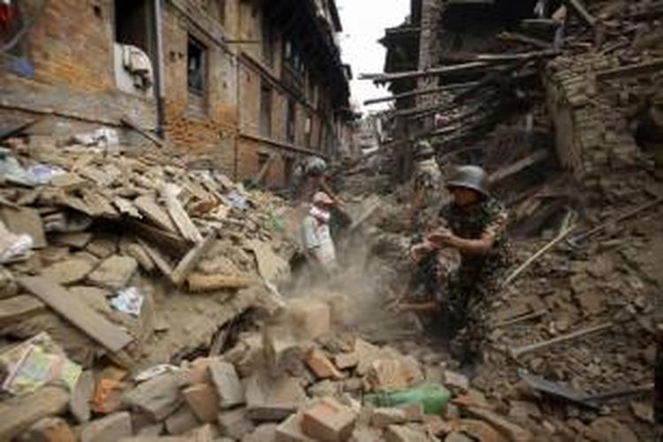 Tim SAR membersihkan puing untuk mencari korban yang tertimbun reruntuhan bangunan setelah diamuk gempa berkekuatan 7.9 SR di Bhaktapur, dekat Kathmandu, Nepal, 26 April 2015.