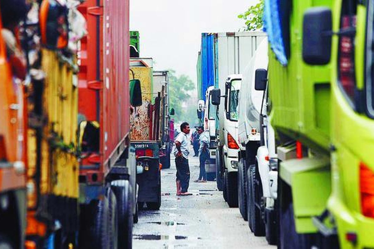 Sopir truk kontainer turun dari kendaraannya, menunggu kemacetan terurai di Jalan Jayapura di Kawasan Berikat Nusantara (KBN), Jakarta Utara, Kamis (15/1). Kemacetan terjadi karena jembatan Marunda di jalur utama ekspor-impor antara KBN Marunda dan Pelabuhan Tanjung Priok ambles.  