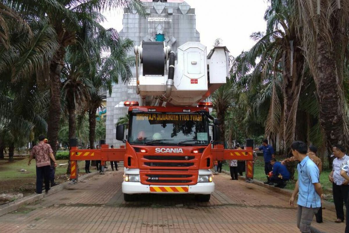 Crane mobil pemadam kebakaran berusaha menjangkau Pucuk Makara Kubah Islamic Center yang miring, Jumat (9/2/2018).