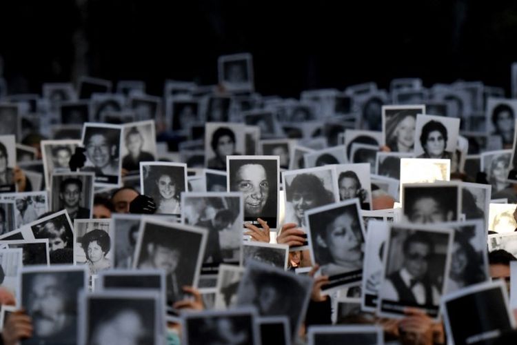Kerabat korban serangan bom ke pusat komunitas Yahudi dari Asosiasi Mutual Israel Argentina (AMIA) yang menewaskan 85 orang dan melukai 300, memegang foto selama ulang tahun ke-28, di Buenos Aires, Argentina, pada 18 Juli 2022.