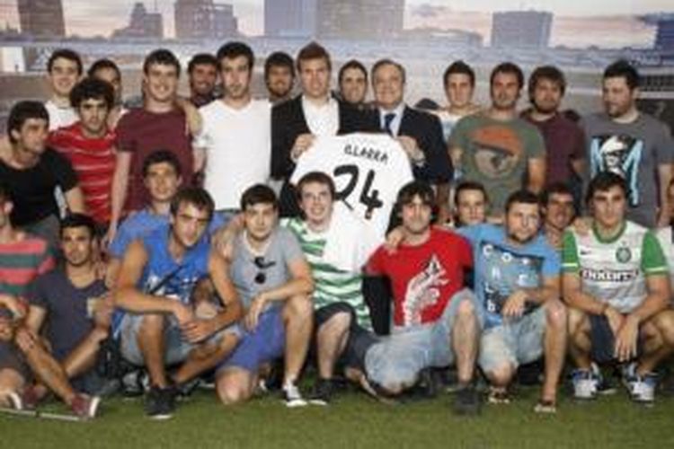Gelandang Asier Illarramendi bersama Presiden Florentino Perez (keduanya memegang kaus nomor 24) dikelilingi teman-teman dekat Illarramendi pada perkenalannya sebagai pemain Real Madrid di Santiago Bernabeu, Sabtu (13/7/2013).