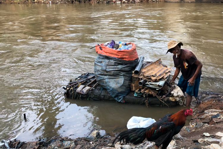 Suparno (69) atau dikenal dengan sebutan Pak Kentir di Sungai Ciliwung di kawasan Manggarai, Tebet, Jakarta Selatan pada Jumat (12/3/2021) sore. Pak Kentir sehari-hari menggantungkan hidupnya kepada Sungai Ciliwung untuk mencari sampah dan barang rongsok.