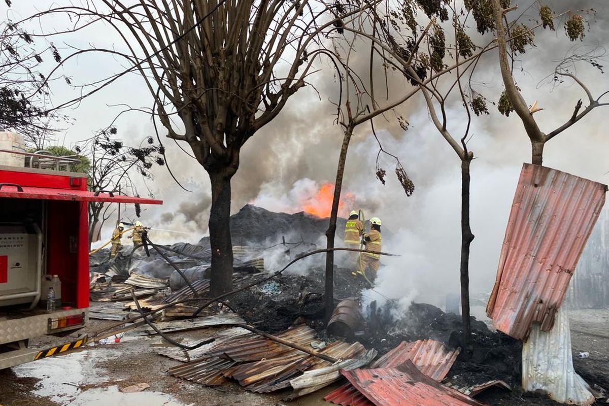 Pemadam kebakaran berjibaku memadamkan api yang melalap lapak plastik daur ulang, Jalan Gaga Rawa Kompeni, Kamal, Kalideres, Jakarta Barat, Jumat (19/5/2023).  